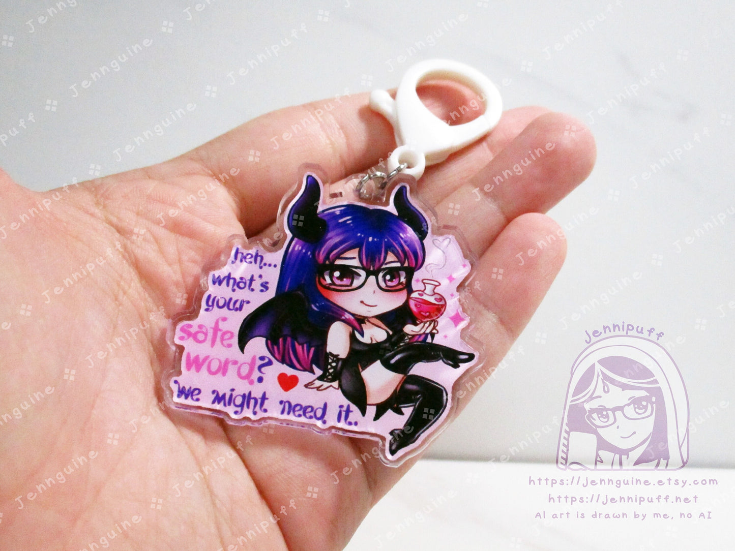 Acrylic double sided keychain with a chibi pink and purple succubus holding a love potion. This photo shows the keychain in the artist's hand.